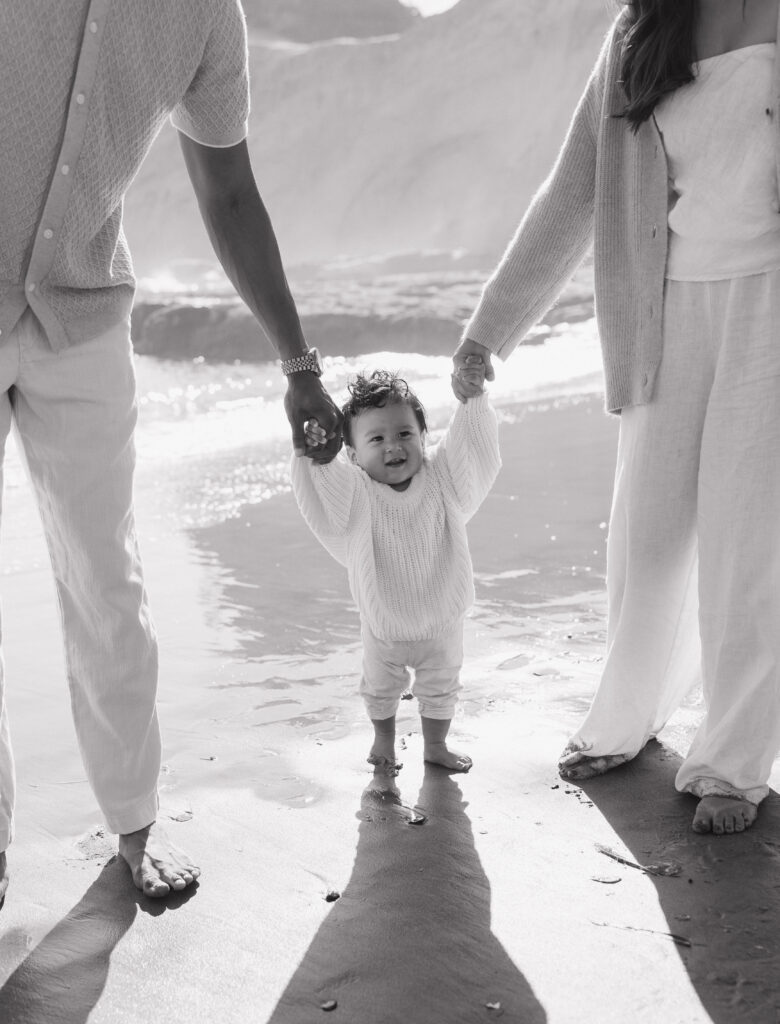 Loving couple embracing on Cape Kiwanda shoreline  
Joyful couple walking along the Cape Kiwanda beach  
Couple sharing a playful moment at sunset on Oregon Coast  
Intimate candid couple photography at Cape Kiwanda  
Parents holding their baby close by the ocean  
Family enjoying tender moments on Cape Kiwanda sand  
Parents laughing with baby on Oregon Coast  
Baby boy snuggled with parents on Cape Kiwanda beach  
Playful family interactions on Cape Kiwanda beach  
Sunset family portraits on Oregon Coast  
Majestic cliffs along Cape Kiwanda coastline  
Rocky sandstone formations at Oregon Coast  
Golden sunset light over Cape Kiwanda shore  
Warm evening glow along Oregon Coast coastline  
Ocean sunset behind couple at Cape Kiwanda