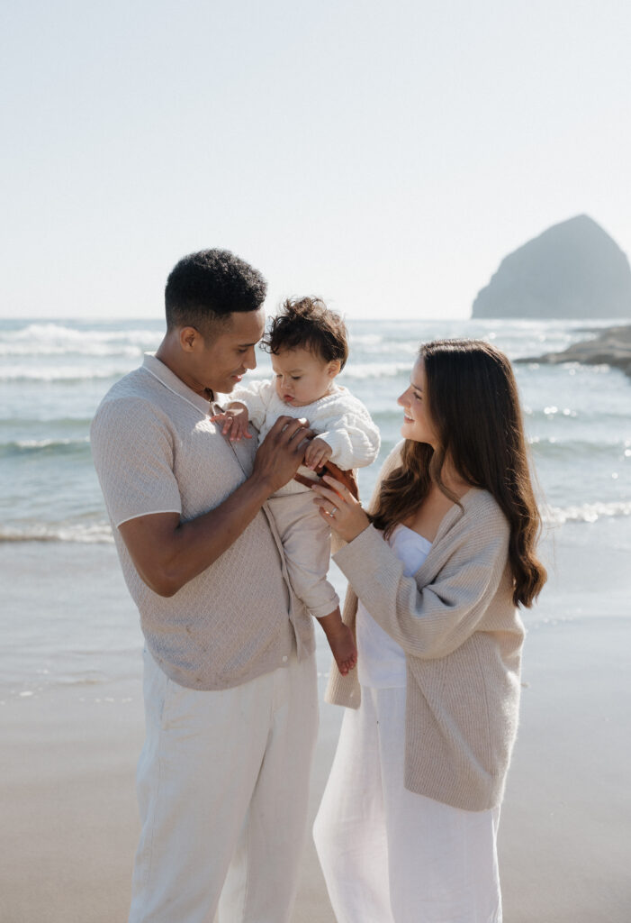 Loving couple embracing on Cape Kiwanda shoreline  
Couple walking along Cape Kiwanda beach  
Couple sharing a playful moment at sunset on Oregon Coast  
Parents holding their baby boy on Cape Kiwanda sand  
Family enjoying tender moments on the Oregon Coast  
Baby snuggled with parents on Cape Kiwanda beach  
Majestic cliffs along Cape Kiwanda coastline  
Rocky sandstone formations on the Oregon Coast  
Golden sunset light over Cape Kiwanda shore  
Ocean sunset behind couple at Cape Kiwanda 